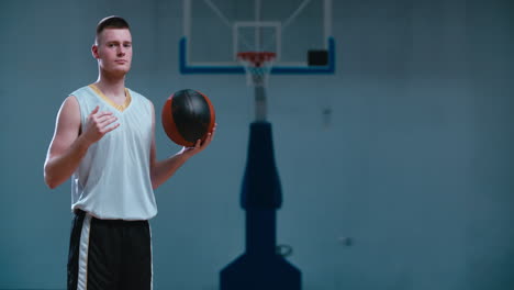 Halbes-Porträt-Eines-Kaukasischen-Männlichen-Basketballspielers,-Der-Drinnen-Mit-Einem-Ball-Posiert.-4k-Uhd